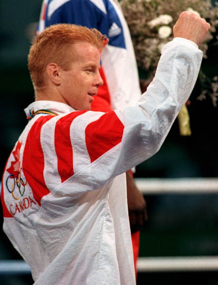 Ginger-haired Mark Leduc, in Team Canada jacket, holds up right fist